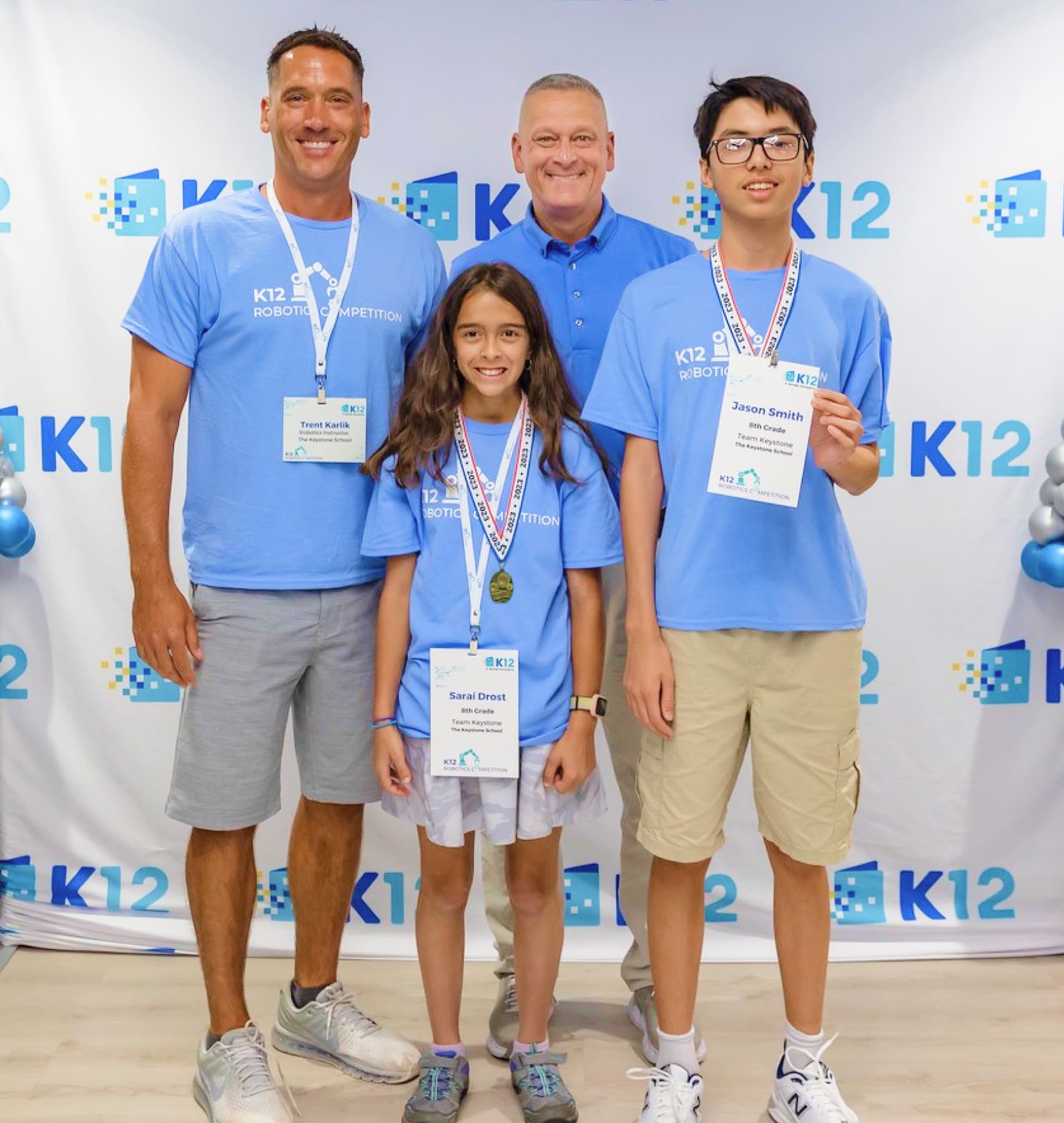 A family proudly displays their medals while posing together for a memorable photo.