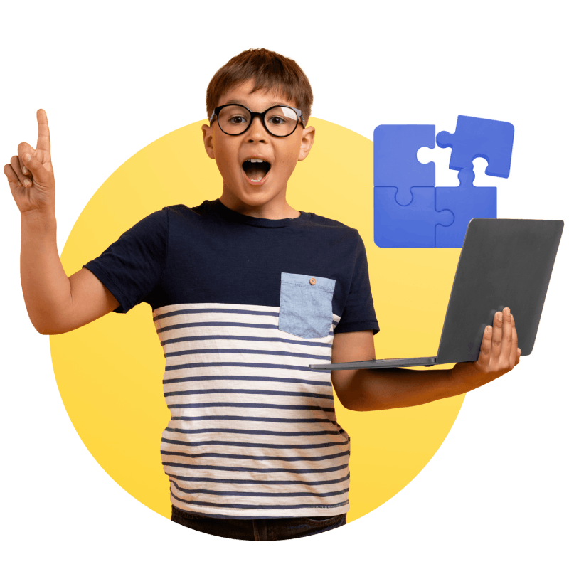 A boy holds a laptop while pointing at a puzzle piece, symbolizing problem-solving and creativity in technology.