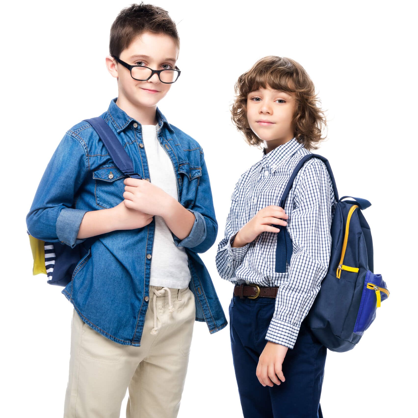 Two boys in school uniforms standing side by side, smiling and engaging in conversation.