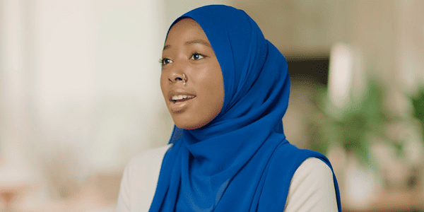 A young woman in a blue hijab, showcasing her cultural attire with grace and elegance.