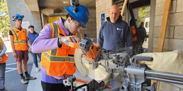 Several people engaged in teamwork while operating a large machine in an industrial environment.