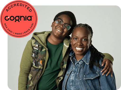 A smiling teenager with glasses and an older woman in a denim jacket embrace warmly, conveying happiness. A red "Cognia Accredited" badge is visible.